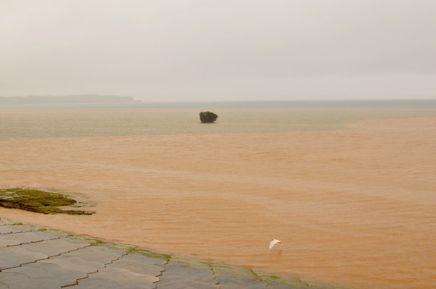 The red earth washed down by the rain stains the sea